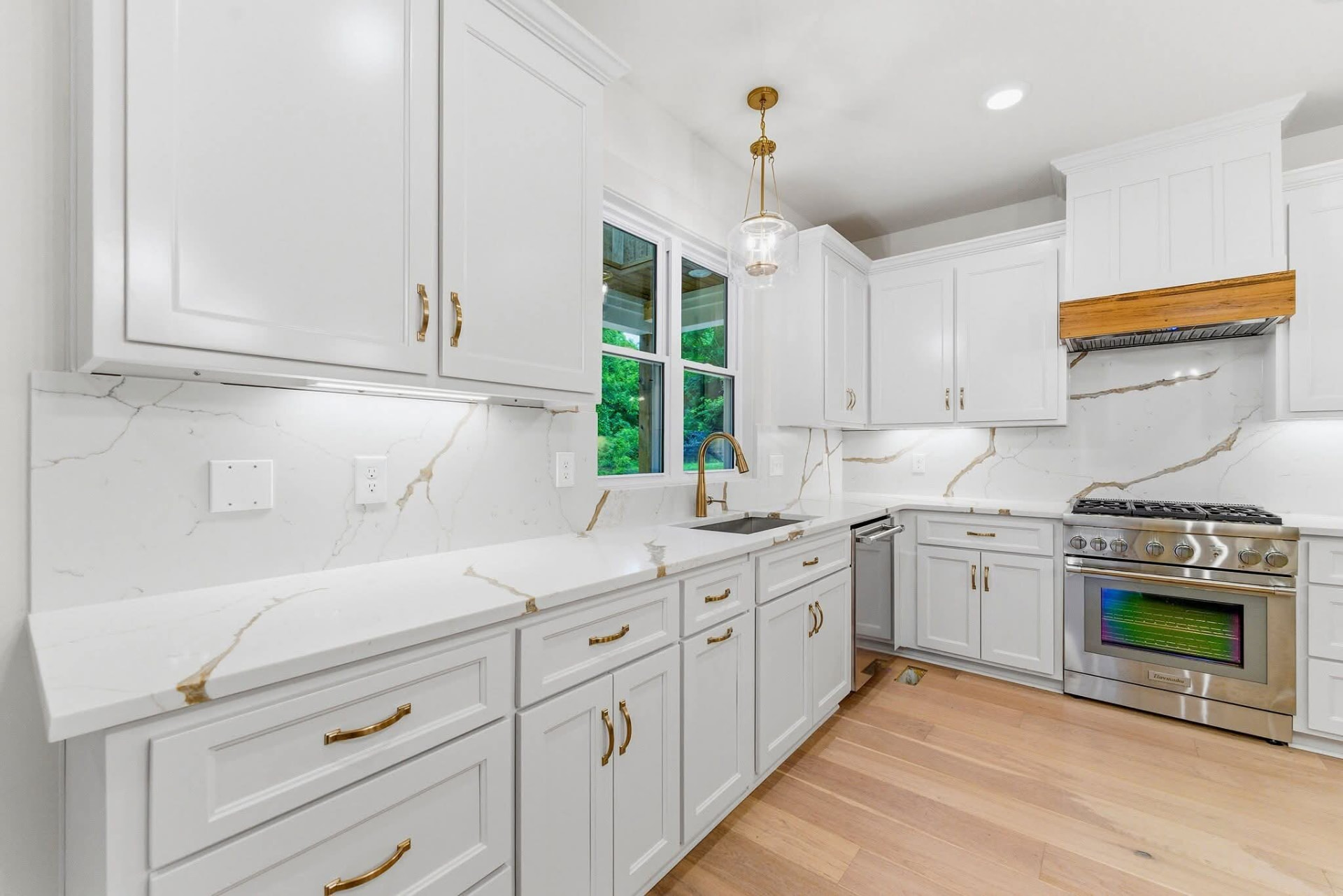 Finished white kitchen with a large natural granite island
